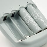 Quatro baterias recarregáveis cinza rotuladas LADDA 1900 em um carregador cinza.