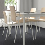 Sala de conferências com mesa branca moderna e cadeiras LÄKTARE bege, pensadas para conforto e empilhabilidade.