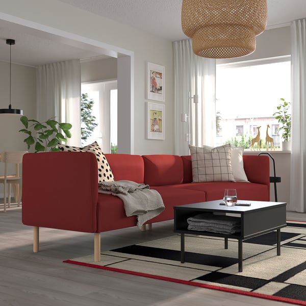 Sofá modular vermelho LILLEHEM na sala de estar, decorado com almofadas, acima da luminária pendente tecida, perto da janela com cortinas brancas.