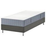 Cama LYNGÖR cinza com colchão azul, com cinco zonas de conforto e molas ensacadas; apoiado por uma base preta com pernas de metal.