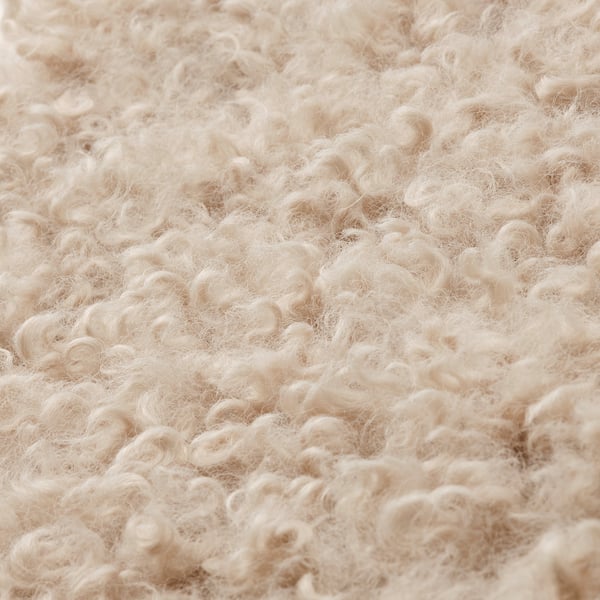 Almofada de cadeira bege fuzzy, textura encaracolada.