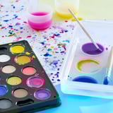 Conjunto de arte infantil vibrante: tintas coloridas, pincéis e copos em caixas duráveis.