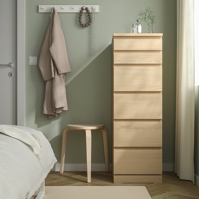 Quarto moderno com cômoda, cama, banquinho e decoração MALM.
