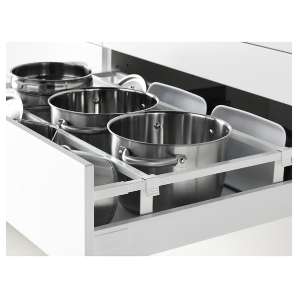 Um organizador de gavetas de cozinha com panelas de aço inoxidável, enfatizando o armazenamento acessível e um mecanismo de fechamento suave e silencioso.