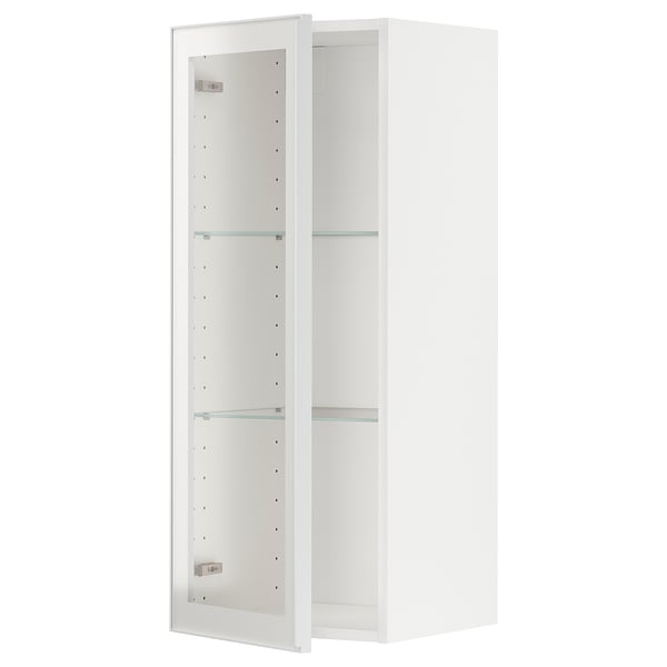 Armário de cozinha branco METOD com prateleiras de vidro e portas com moldura metálica. O armário tem uma prateleira ajustável e um design moderno.