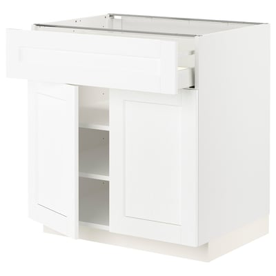 Armário de cozinha branco com única porta e prateleira.