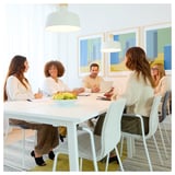 Grupo na mesa de conferência MITTZON branca na sala de reuniões moderna com arte abstrata.