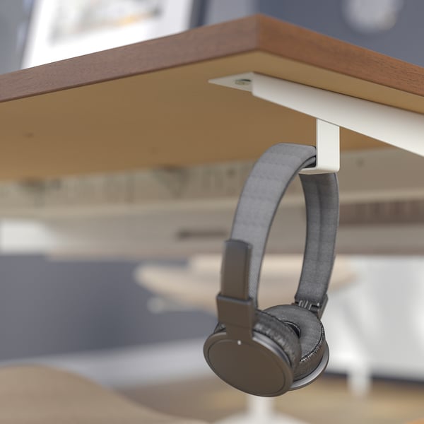 Os fones de ouvido ficam perfeitamente pendurados no gancho de mesa MITTZON, mantendo o espaço de trabalho organizado.