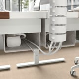 Mesa com mecanismo de altura ajustável e bandeja de gerenciamento de cabos.