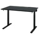 Uma mesa preta MITTZON ajustável em altura com pernas de metal e tampo de madeira escura. Inclui gerenciamento de cabos e ganchos, projetados para uso ergonômico.