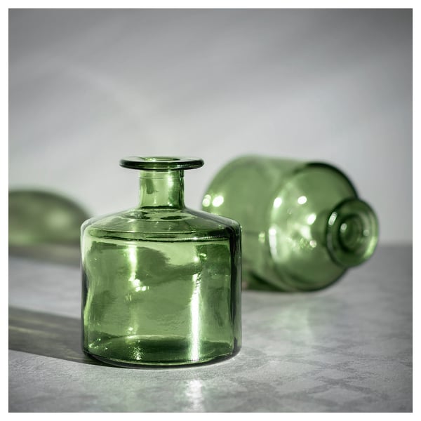 Três vasos de vidro reciclado verde em vários formatos.