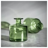 Três vasos de vidro reciclado verde em vários formatos.