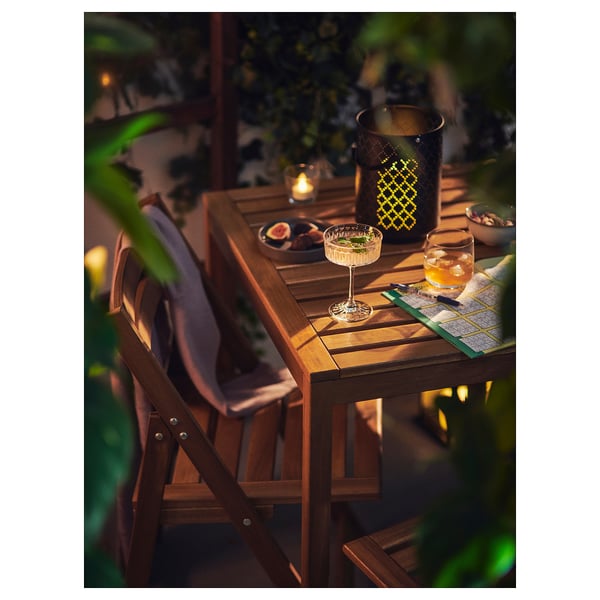 Conjunto Nammaro: mesa e cadeiras ao ar livre com lanches, velas e cobertor para noites aconchegantes.