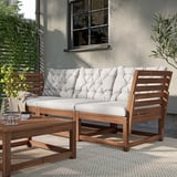 Conjunto lounge ao ar livre: sofá em forma de L com almofadas brancas e laterais de madeira, inclui mesa.