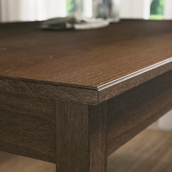 Mesa de jantar de madeira escura com borda chanfrada elegante, mostrando artesanato fino e design robusto.