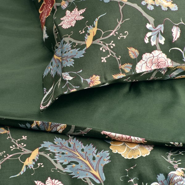 Roupa de cama verde escuro com padrão floral, suave e elegante, exibindo desenhos intrincados de folhas e flores.