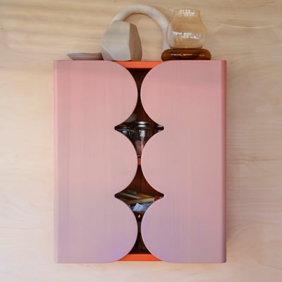 Armário OMMJÄNGE cor-de-rosa com portas curvas exibindo itens.