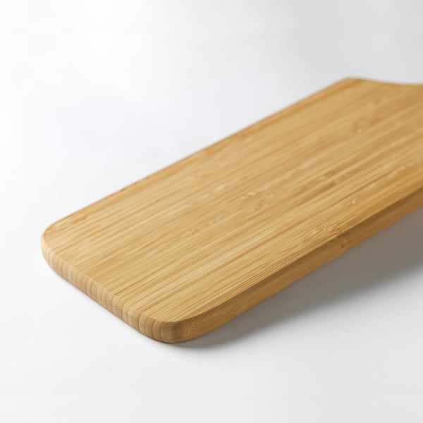 Tábua de corte de bambu retangular lisa em uma superfície branca.