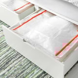 PÄRKLA saco de arrumação numa gaveta, com um objeto branco. A bolsa com zíper armazena itens sazonais, dobra-se quando vazia.