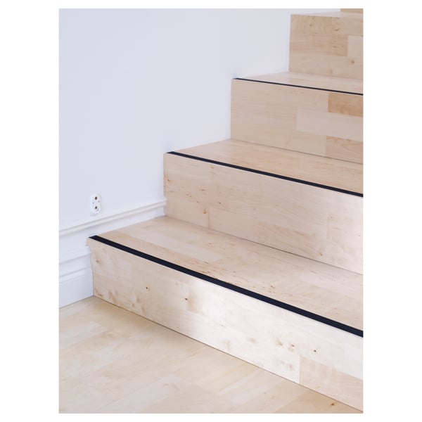 Escadas de madeira com tiras antiderrapantes pretas em cada degrau para segurança.