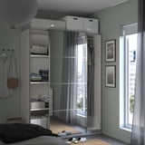 Quarto moderno com roupeiro ikea PAX, portas espelhadas e luz natural.