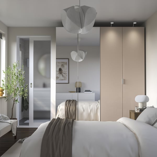 Quarto moderno em tons neutros com cama flutuante, espelho grande, candeeiros de flores pendurados, unidade de arrumação PAX incorporada. Decoração luminosa e minimalista.