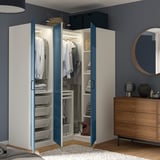 Quarto moderno com roupeiro PAX, portas azuis abertas, com soluções de arrumação organizadas.