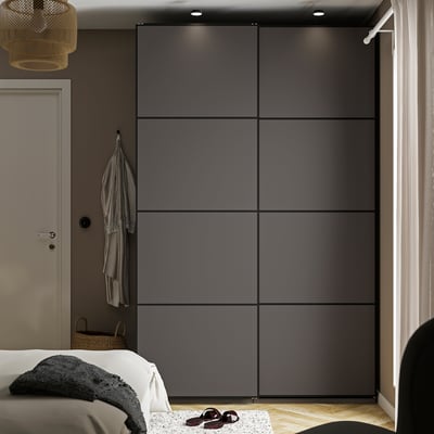 Quarto moderno com grande guarda-roupa PAX, cama branca e decoração.