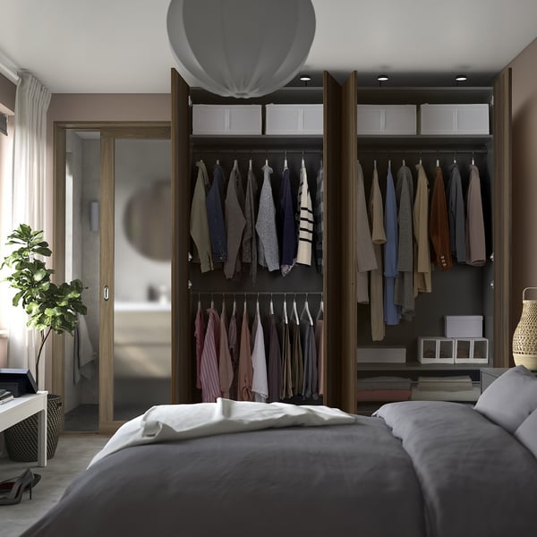 Quarto moderno com guarda-roupa aberto exibindo roupas, usando pés ajustáveis para nivelamento do piso e amortecedores integrados para fechamento suave da porta.