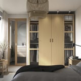 Quarto moderno com roupeiro PAX e painéis de vidro.