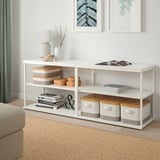 O módulo de arrumação PLATSA branco, fino mas alto, adapta-se perfeitamente a um sofá bege. Armazena livros, decoração e tem seções abertas.