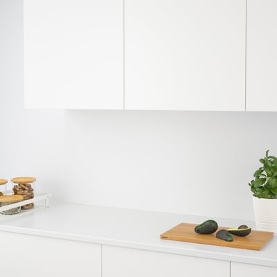 Balcão de cozinha moderno com abacates e plantas, com parede resistente a quartzo e armazenamento elegante.