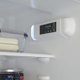 Um refrigerador moderno com uma prateleira ajustável contendo manteiga e um painel de controle digital para configurações.