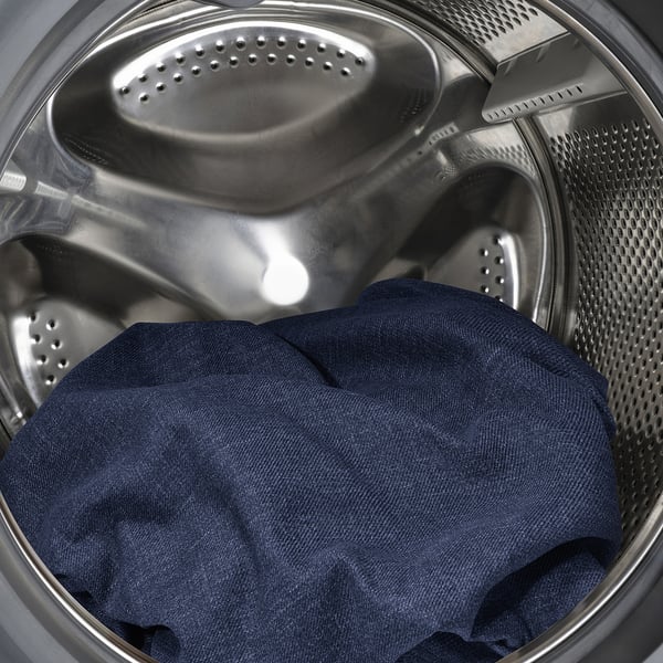 Interior da máquina de lavar roupa com tecido escuro no interior, mostrando característica lavável na máquina.