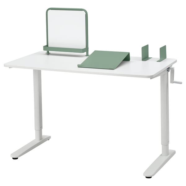 Mesa branca ajustável com acessórios verdes, quadro branco magnético, bloco de notas e apoios para livros. A manivela ajusta a altura de 65 a 108 cm.