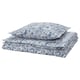 Um conjunto de cama com estampa paisley azul e branco, com capa de edredom e fronhas, cuidadosamente dobradas.