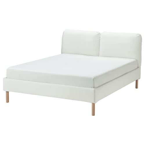 Cama estofada branca moderna com cabeceira inclinada e pernas de madeira.