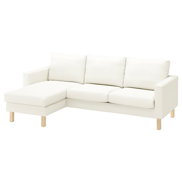 Um sofá modular branco SALTSJÖBADEN com tecido leve, textura ligeira, pernas de madeira e uma chaise longue de canto.