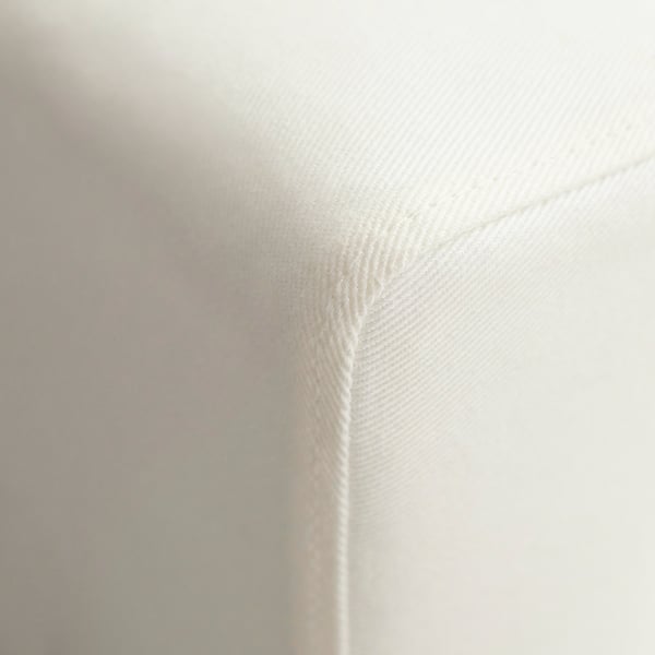 Plano aproximado de um material branco e macio de sofá; suave mas texturizado.