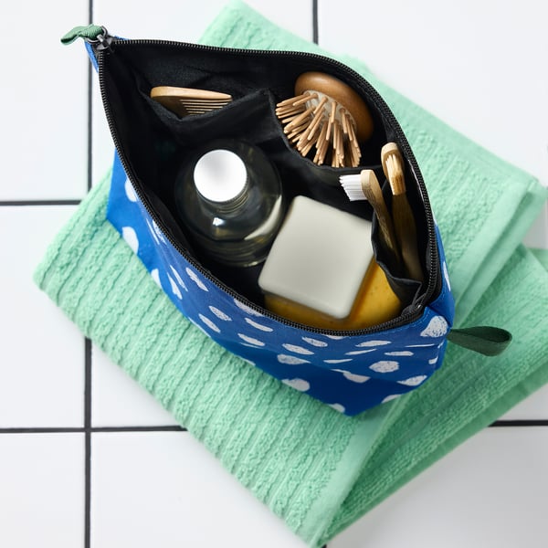 Nécessaire azul com pontos brancos. Poliéster reciclado, vários compartimentos.