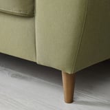 Sofá moderno verde-oliva com pernas de madeira, encosto alto e almofadas.