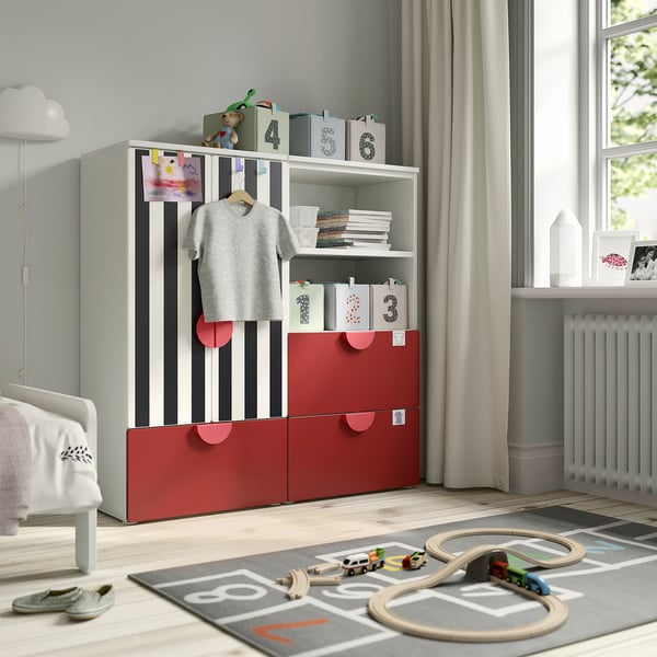 Quarto infantil com guarda-roupa SMÅSTAD vermelho e branco, brinquedos, livros, moletom, trilho de trem.