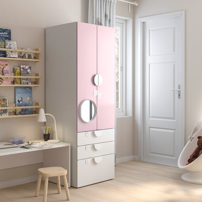 Quarto infantil com guarda-roupa rosa-branco, estantes, mesa, lâmpada e balanço de ursinho de pelúcia.