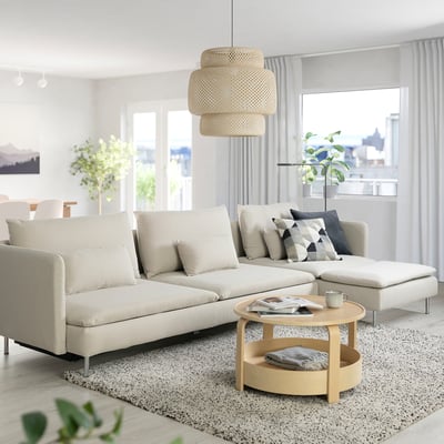 SÖDERHAMN sofá-cama branco, acolhedor ou arejado, com almofadas e mesa de centro, contra grandes janelas com cortinas claras.