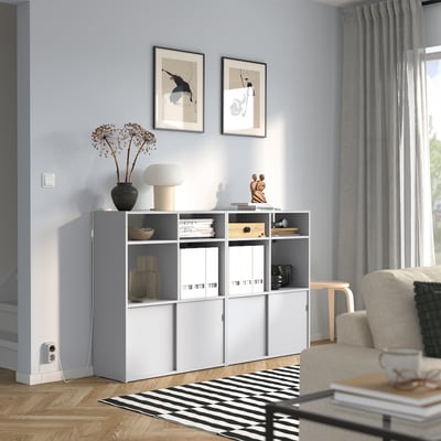 Sala de estar azul claro moderna com unidade de armazenamento cinza-branco e tapete preto e branco.