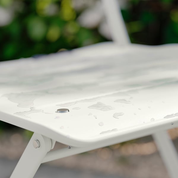 Superfície de mesa de metal branco com gotas de água, configuração ao ar livre.