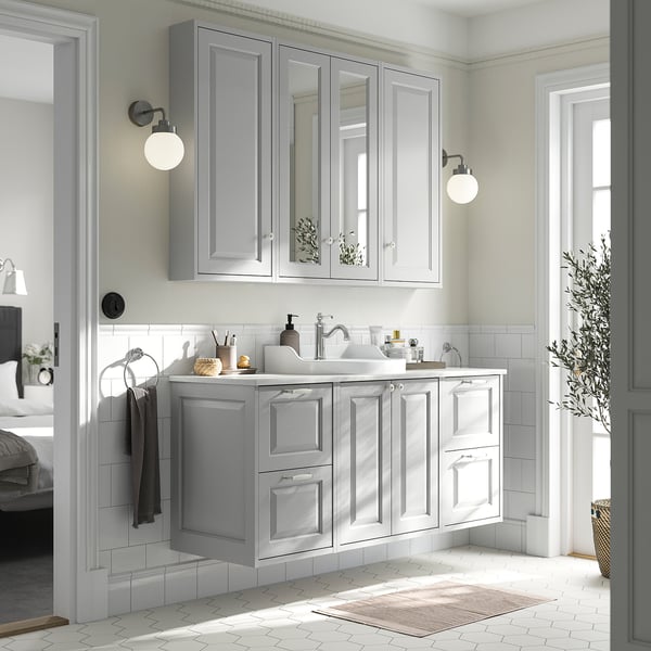 Um moderno armário de casa de banho TÄNNFORSEN cinzento com bancada em mármore, lavatório e armários espelhados, que se encaixa perfeitamente no espaço de banho.