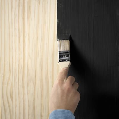 Uma lata de tinta cinza ikea TRIXIG, cilíndrica com tampa redonda, rotulada com ícones e texto para uso em superfícies de madeira e metal.