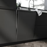 Cozinha moderna com armários UPPLÖV pretos elegantes com puxadores integrados e lava-loiça em aço inoxidável.