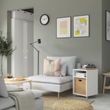 Sala de estar moderna com sofá VIHALS branco, mesa lateral, arte de parede e tapete.